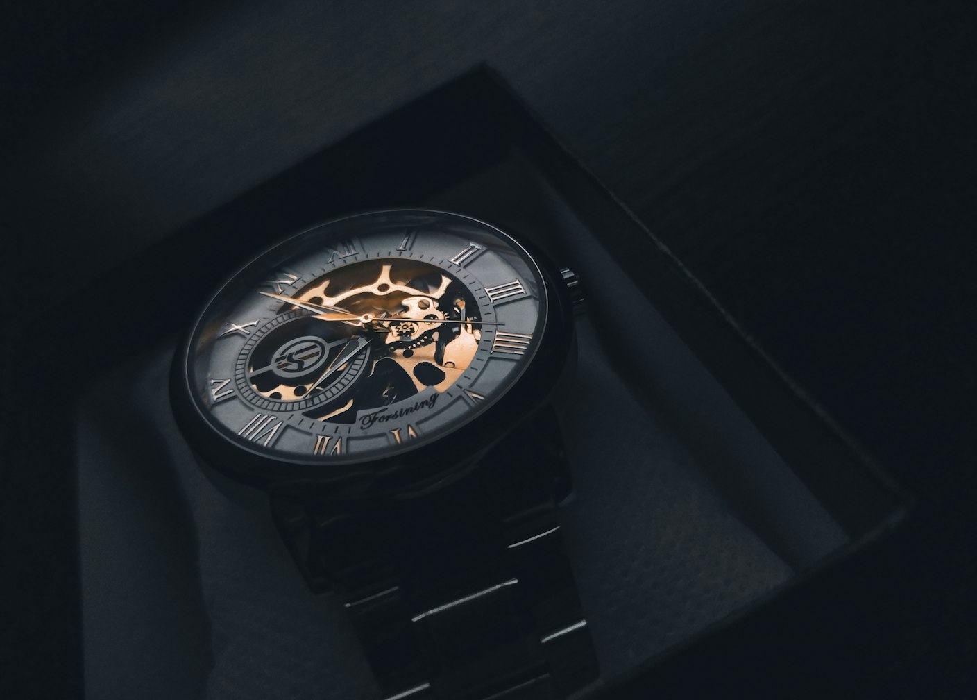 Skeletonised gold dress watch on a leather strap worn on the wrist